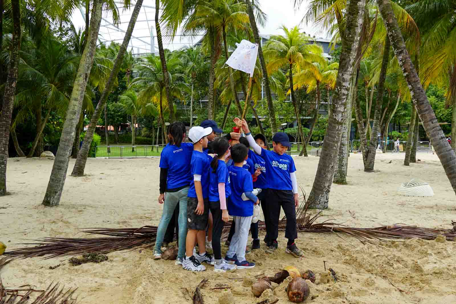 southern voyagers holiday camp children holding team flag at beach